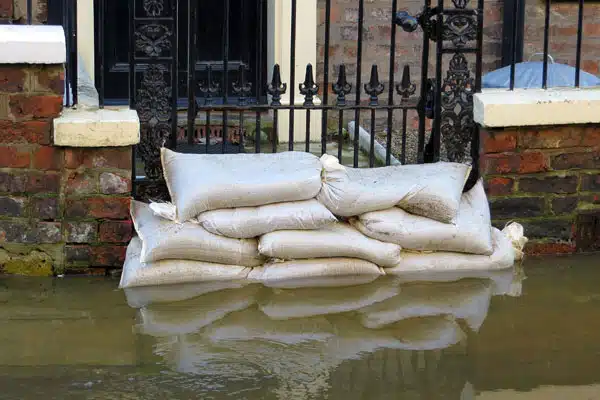 Sand bags in use in front of a flooded home entrance